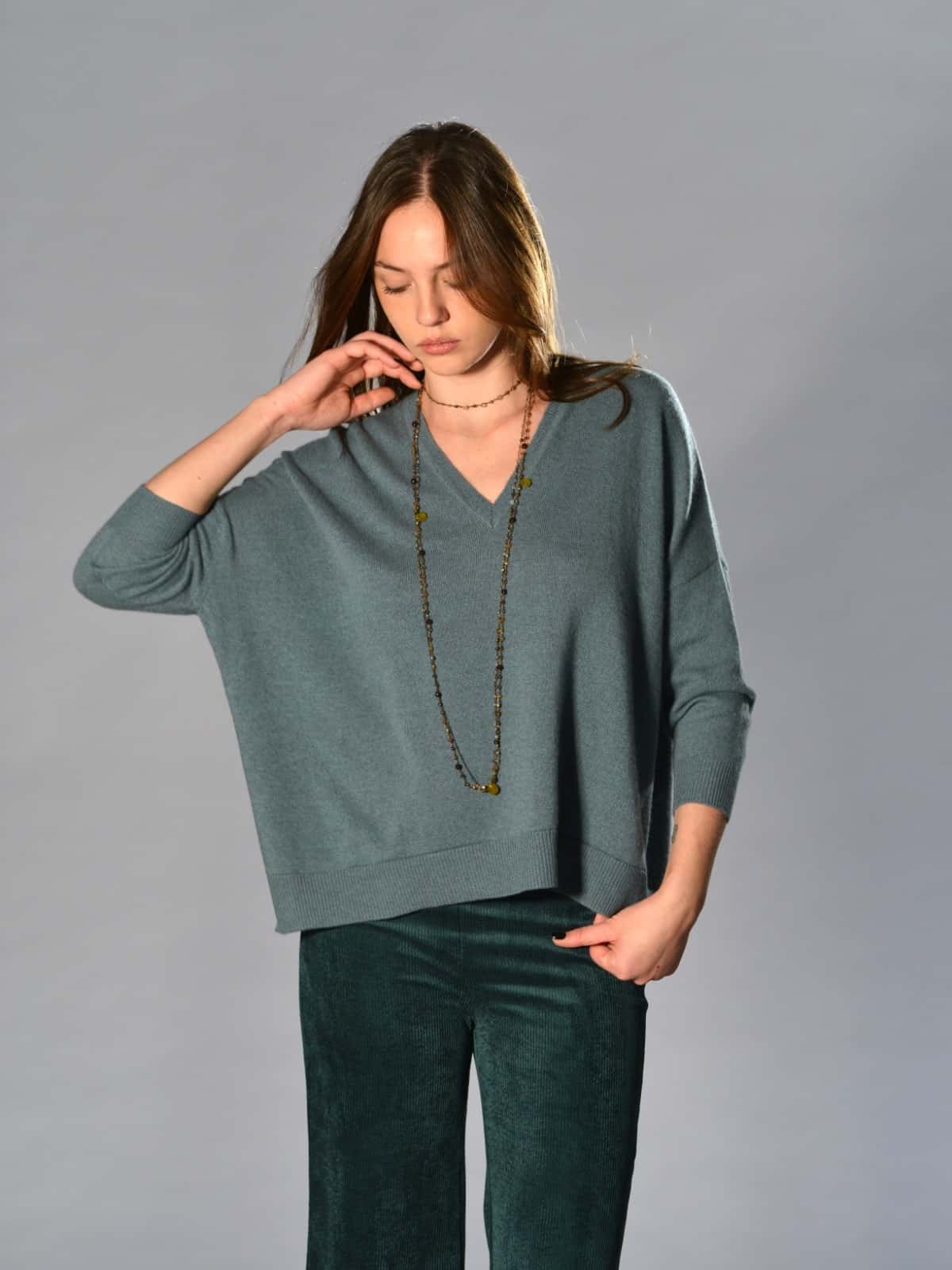 Maglia over boxi Marina Lari in cashmere melange verde acqua, con scollo a V profondo, lati completamente aperti e manica 3/4 – maglieria leggera e raffinata