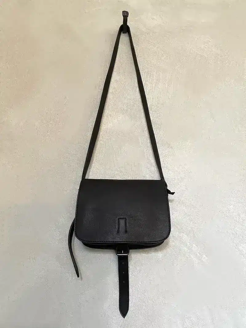 Piccola borsa a tracolla in pelle nera Christian Peau, made in Japan, con chiusura a fibbia e due tasche interne.