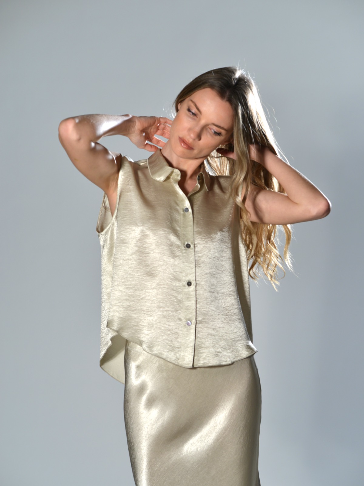 Camicia over corta smanicata Marina Lari in acetato greige, con chiusura frontale a bottoni e orlo arrotondato