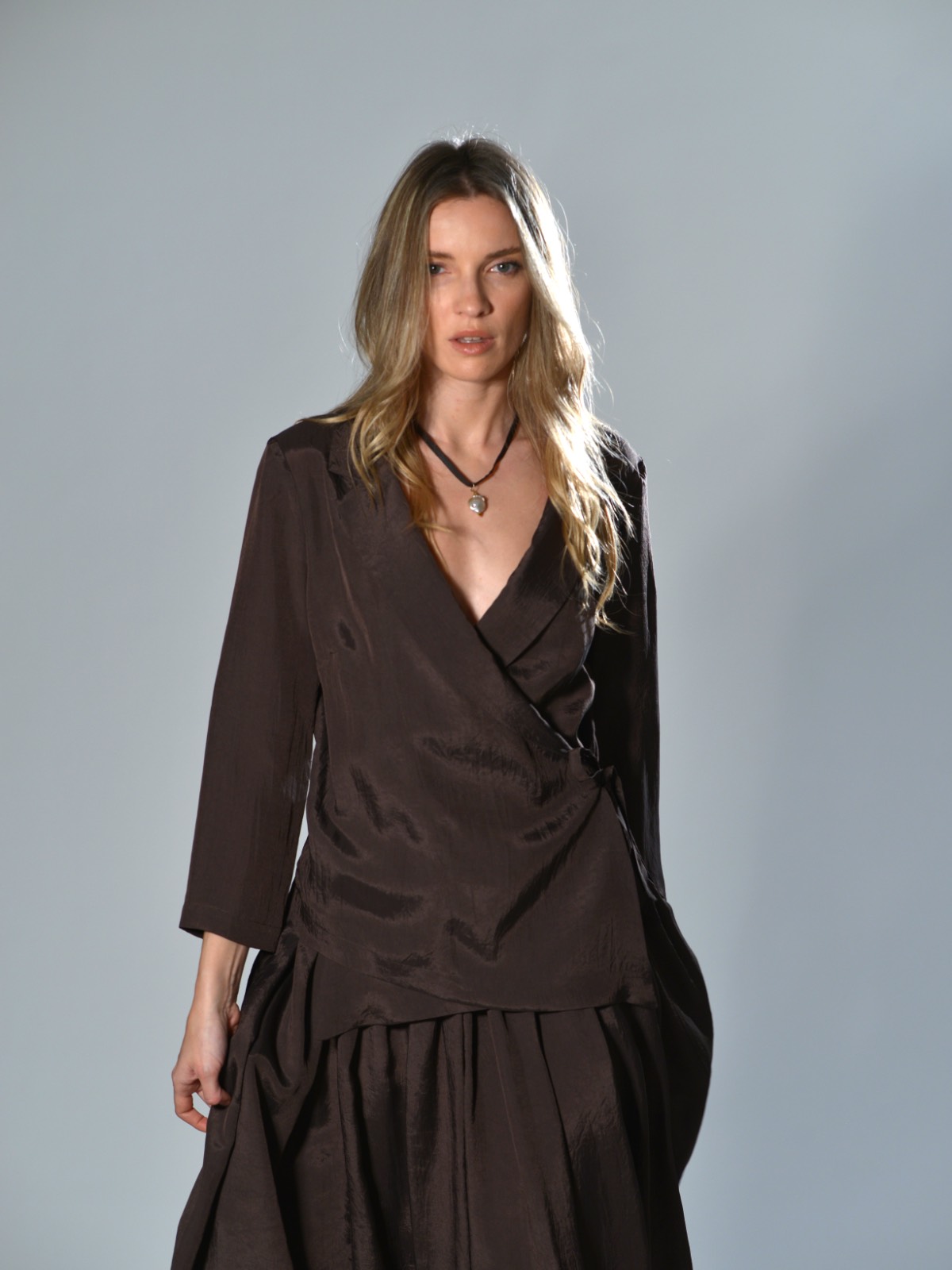 Giacca incrociata Marina Lari in acetato marrone, con rever ampio, chiusura laterale con laccetto e fondo asimmetrico