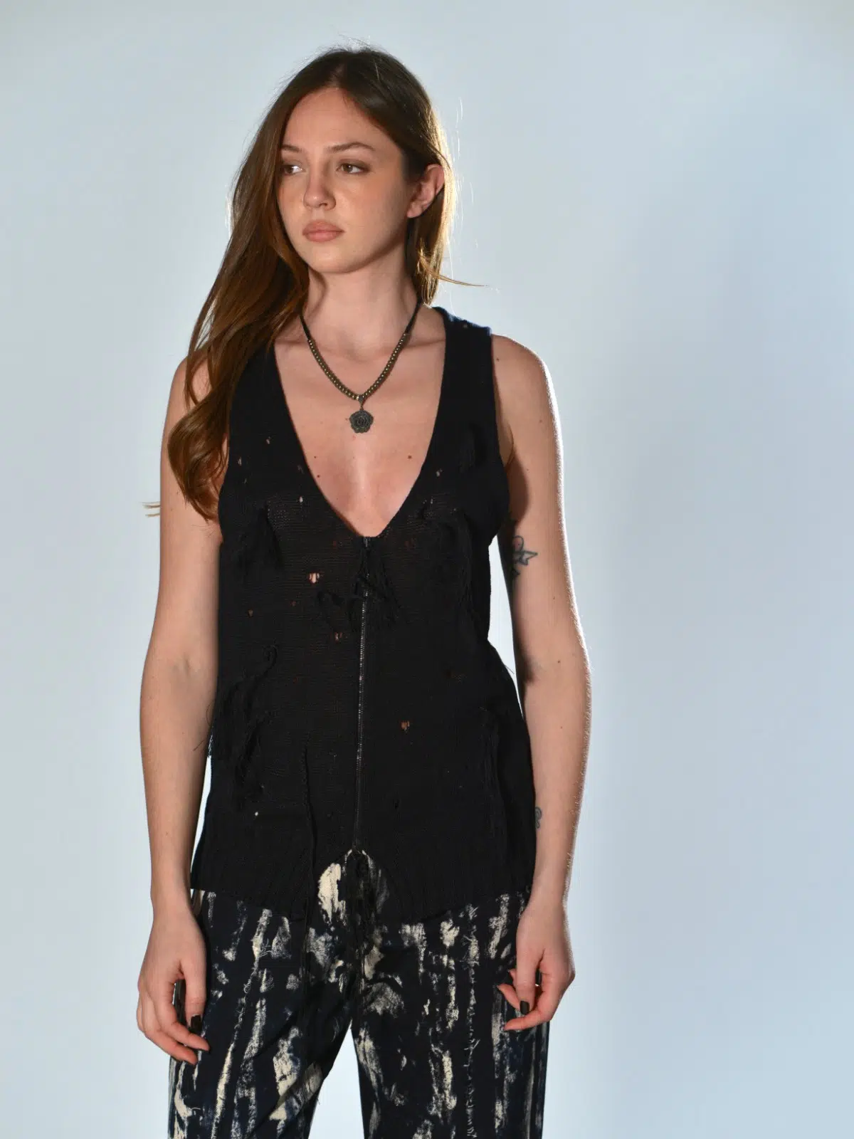 Gilet nero Serie Numerica in maglia traforata con nappine applicate a mano