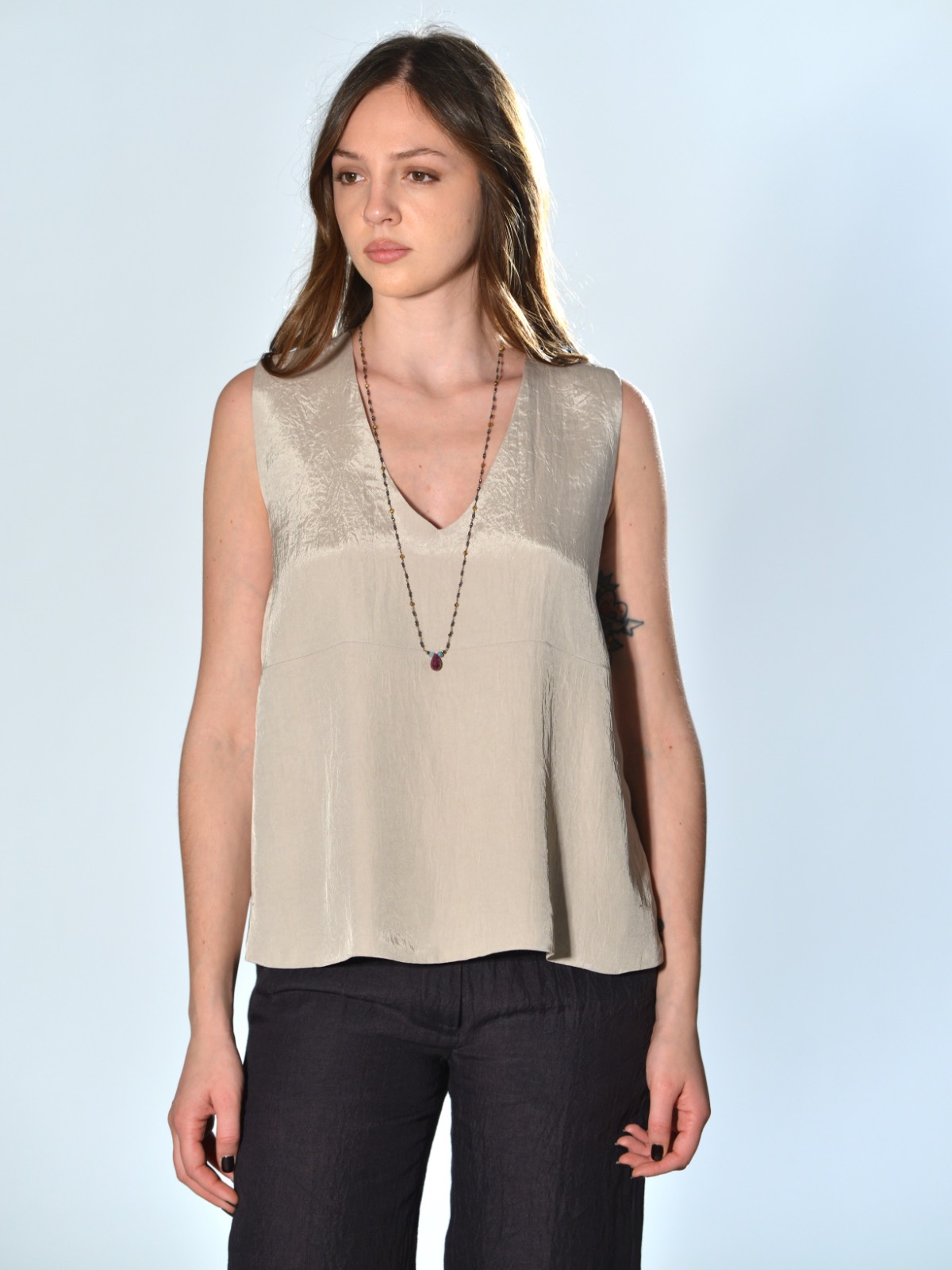 Top oversize Marina Lari in acetato marrone, con scollo a V profondo, tasche laterali a marsupio e linea svasata