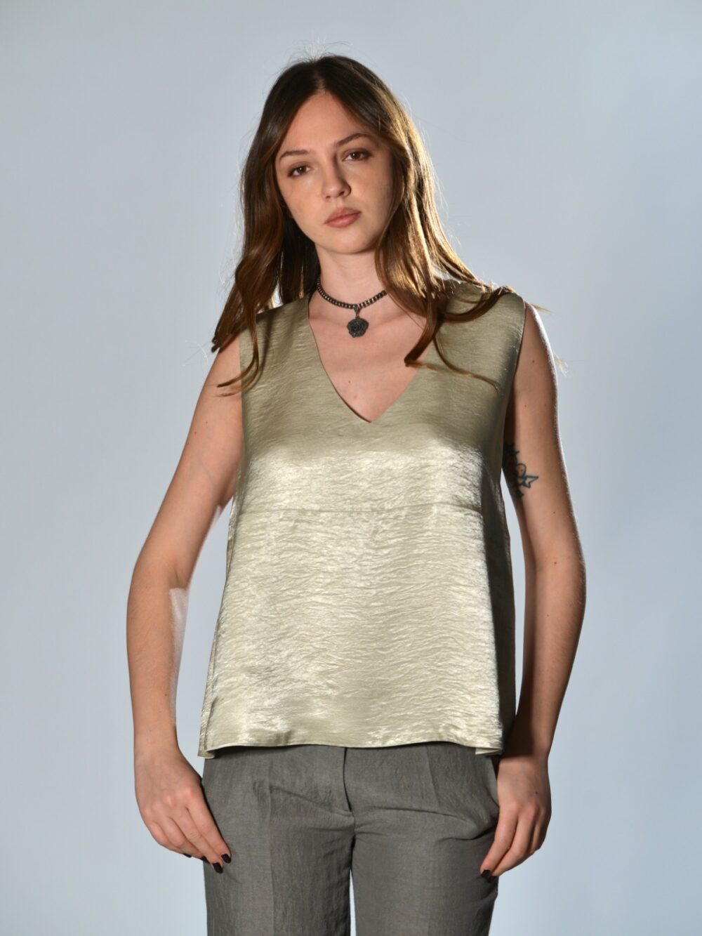 Top oversize Marina Lari in acetato greige, con scollo a V profondo e tasche laterali a marsupio