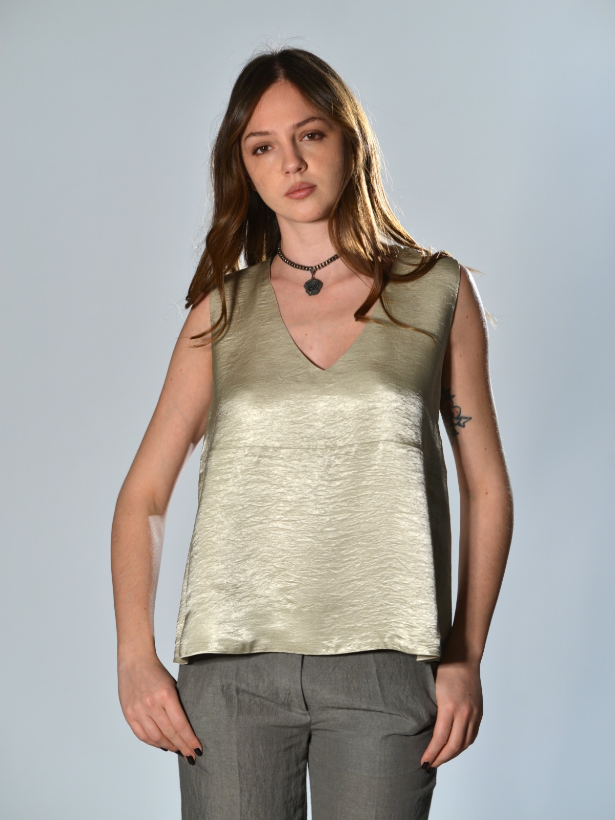 Top oversize Marina Lari in acetato greige, con scollo a V profondo e tasche laterali a marsupio