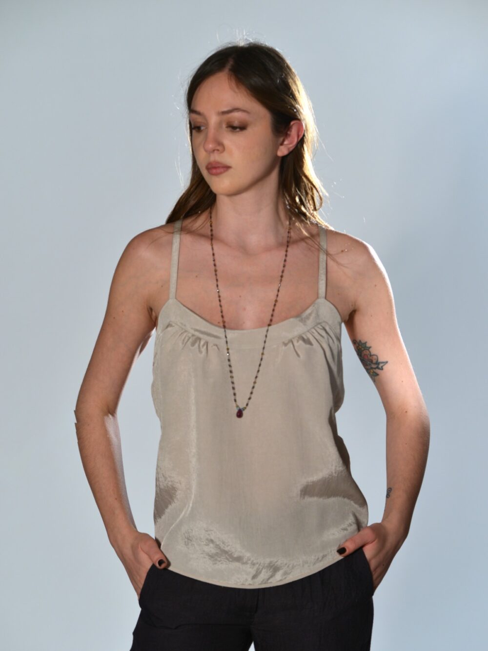 Top scollato Marina Lari in acetato beige, con spalline sottili, schiena con spalline incrociate e dettagli cut-out laterali