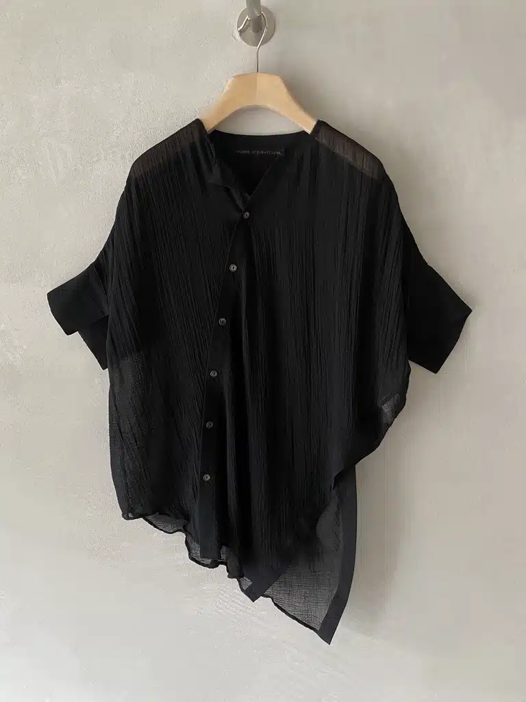 Asymmetrical shirt in semi-sheer cotton and silk with pleated surface, open collar and wide short sleeves with pointed hem in black - FORME D’EXPRESSION