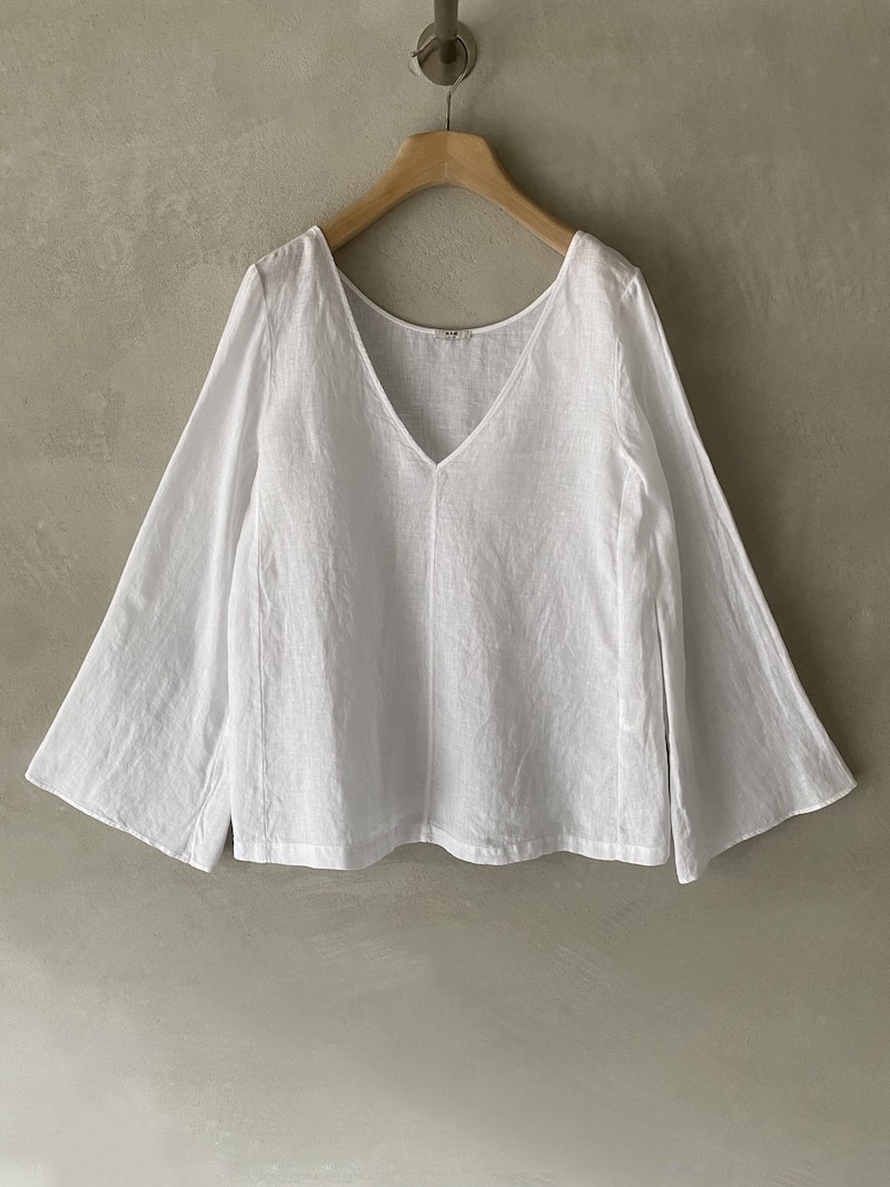 Blusa bianca in lino dalla linea svasata con scollo a V e maniche a campana, vestibilità morbida MSM Milano