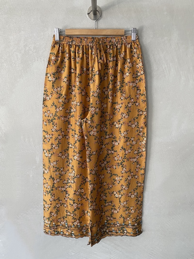 Pantalone giallo ocra con stampa floreale e gamba larga, fondo con ricamo decorativo Maku