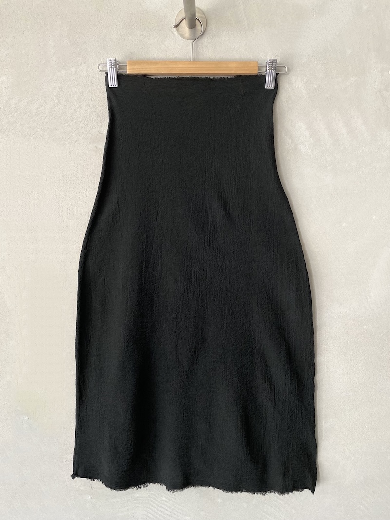 Gonna tubino nera in materiale elasticizzato con superficie increspata e fondo irregolare a taglio vivo, linea aderente Marc Le Bihan