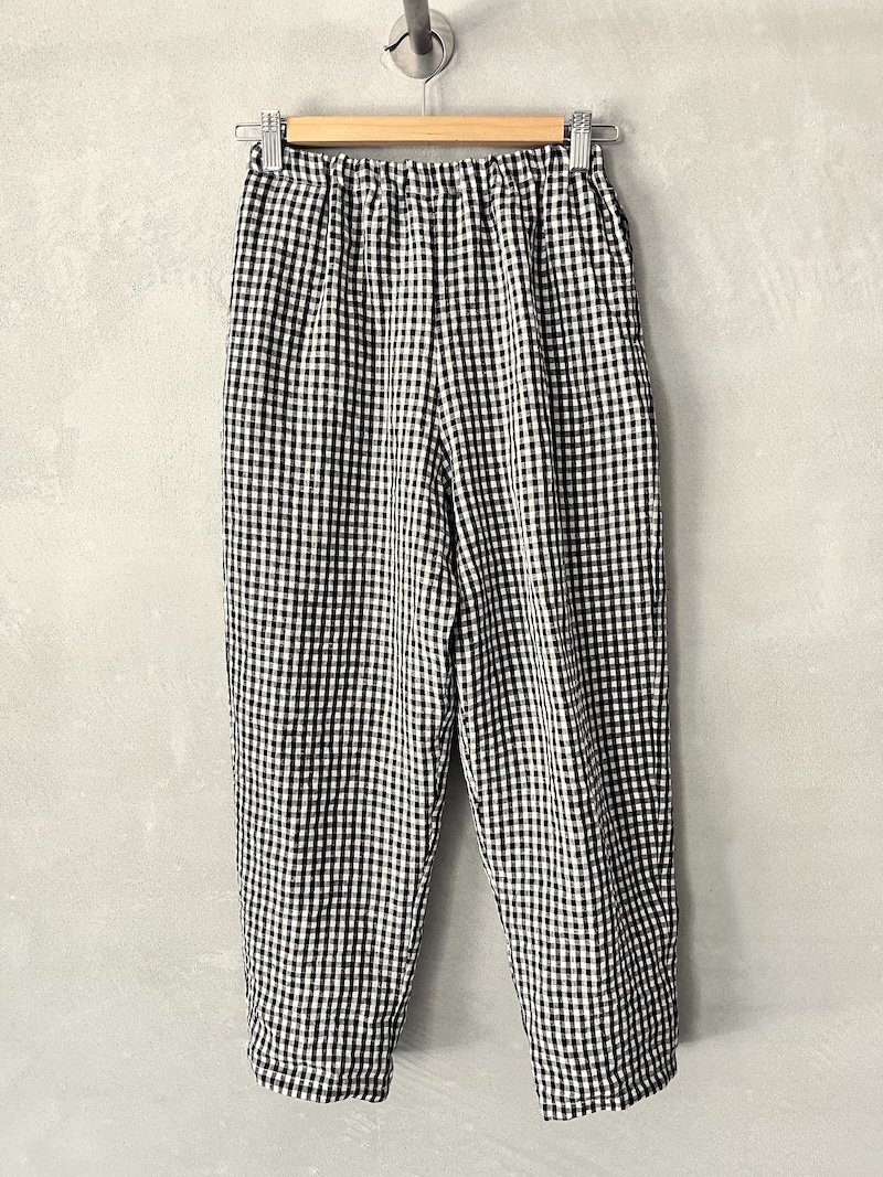 Pantaloni in lino vichy colore bianco e nero con vita elasticizzata arricciata, linea dritta, tasche laterali e fondo con orlo impunturato Apuntob