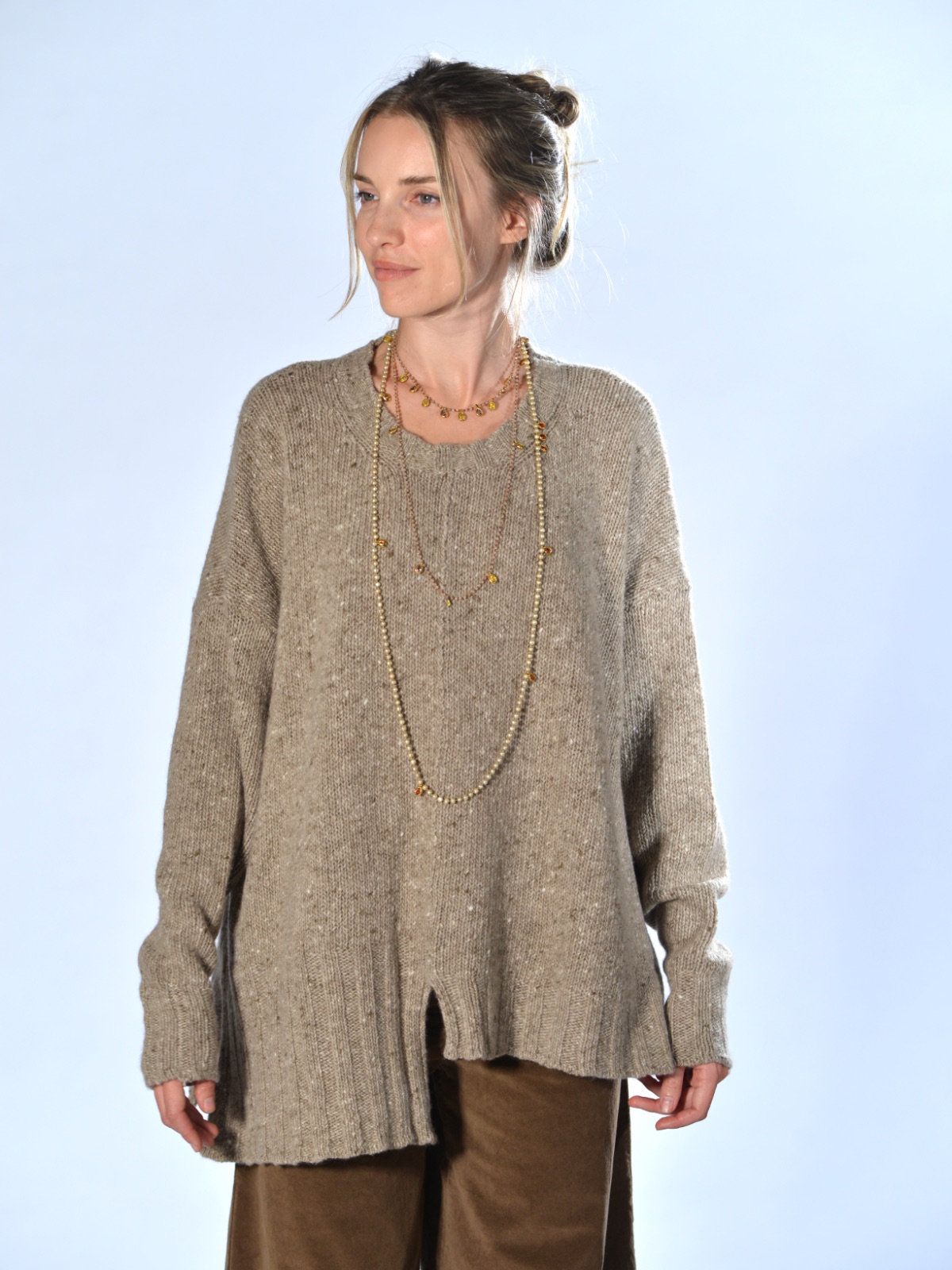 Maglione oversize beige in cashmere e lana tweed, con fondo asimmetrico, spacco centrale e cuciture a vista, Marina Lari.