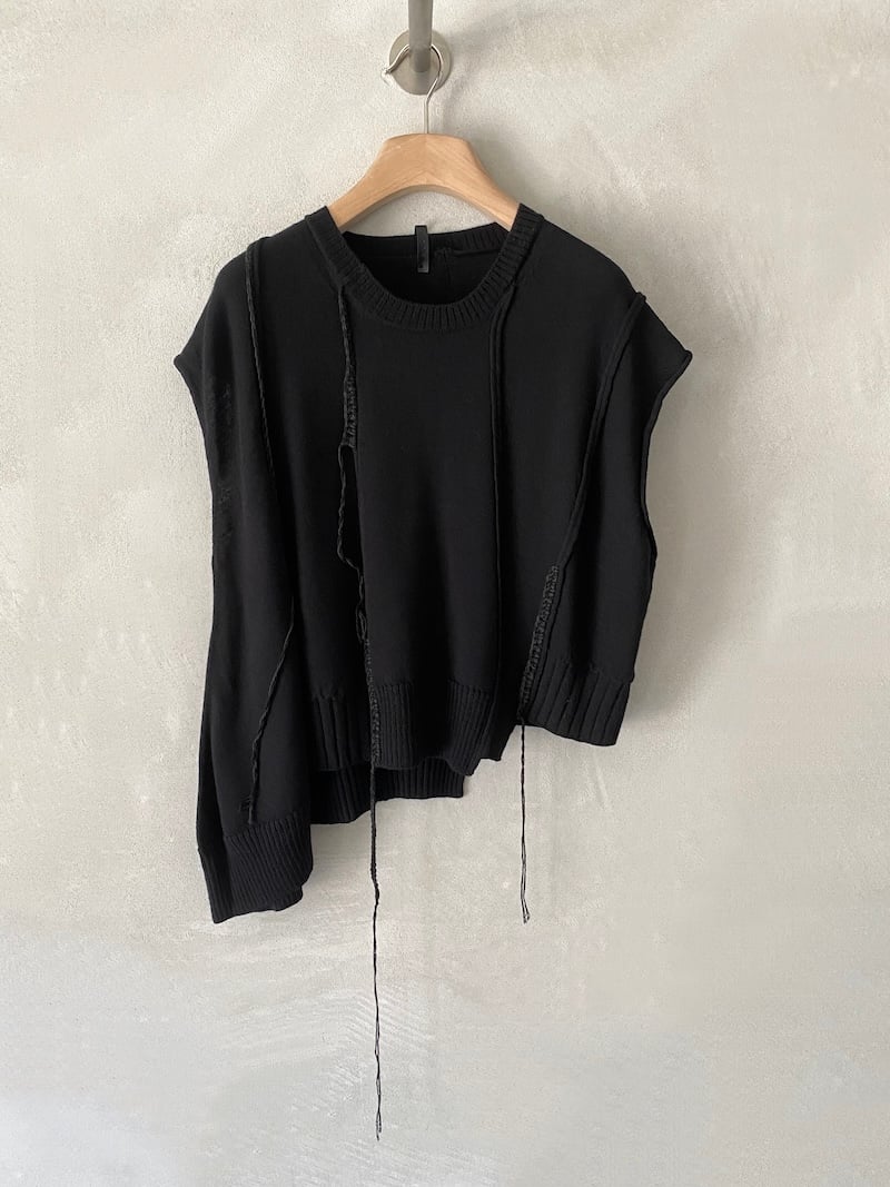 Gilet nero oversize in maglia con lunghezze asimmetriche, cuciture esterne e fili pendenti, Serie Numerica.