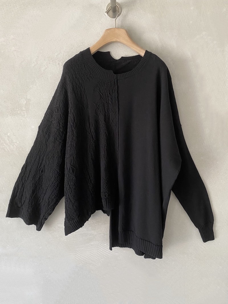 Maglia nera oversize in lana merino extrafine, composta da due metà differenti con lavorazione a rilievo e liscia, Serie Numerica.