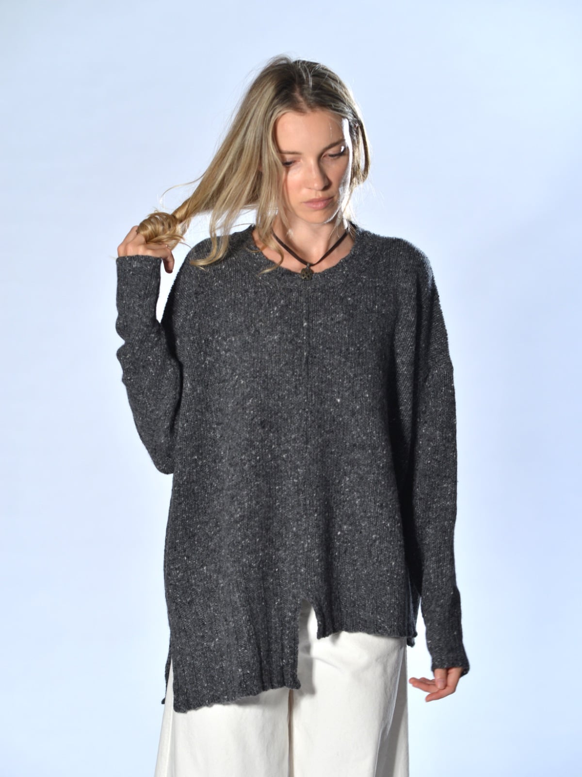 Maglione oversize grigio in cashmere e lana tweed, con fondo asimmetrico, spacco centrale e cuciture a vista, Marina Lari.