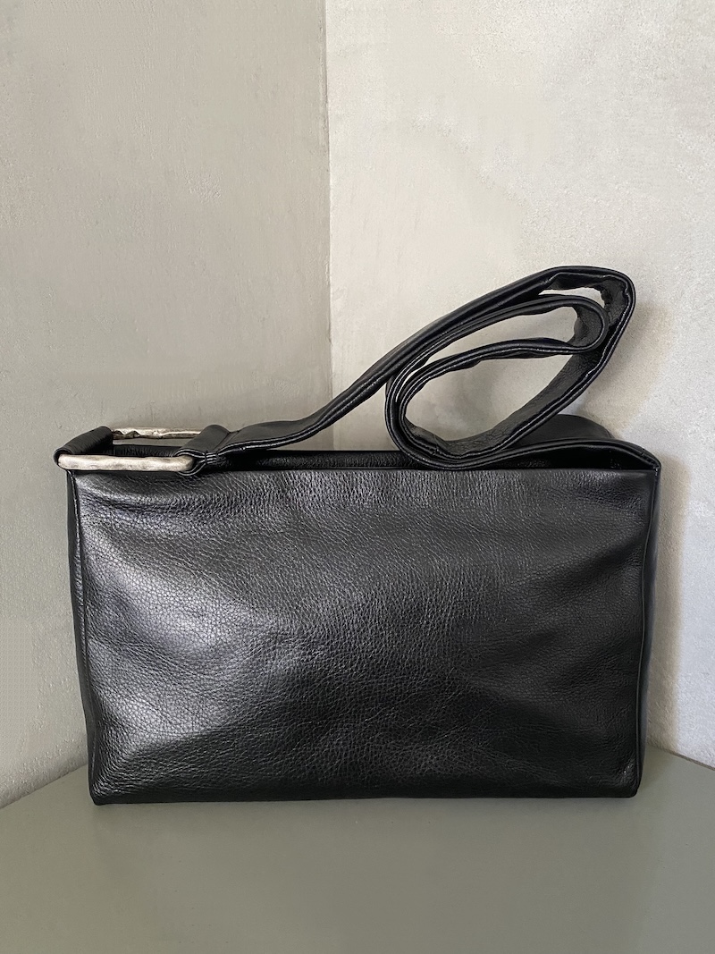 Rectangular black leather bag with shoulder strap and aged silver zamak detail - AUTENTICA504 Rectangular black leather bag with a soft structure, long shoulder strap, and rectangular metal element in aged silver-effect zamak - AUTENTICA504