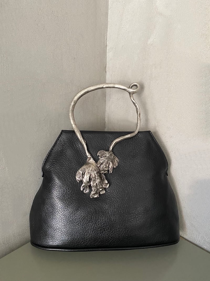 Borsa rettangolare in pelle nera con struttura morbida, tracolla lunga ed elemento metallico rettangolare effetto argento invecchiato - AUTENTICA504