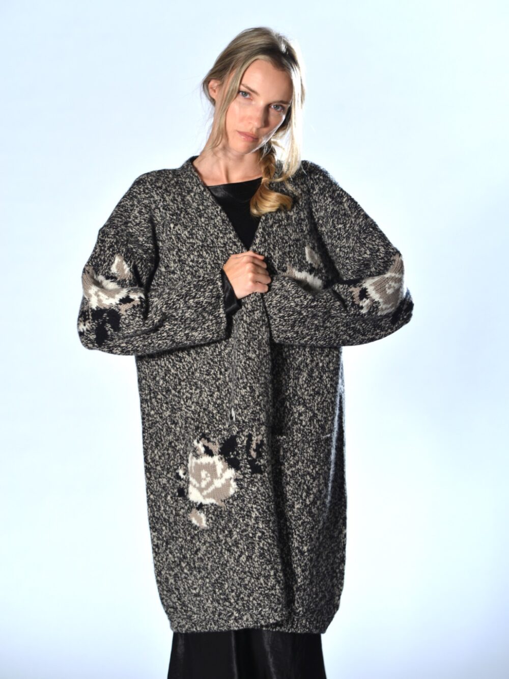 Cardigan lungo nero in lana merino chiné, con intarsi floreali a contrasto, tasche applicate e vestibilità over, Marina Lari.