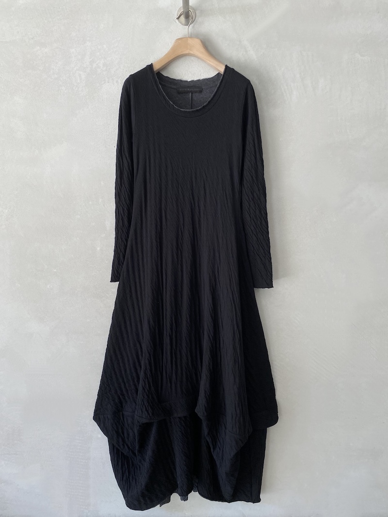 Abito lungo nero in maglina goffrata e doppiata, con linea aderente sul torace, fondo ampiamente svasato e asimmetrico, Marina Lari.