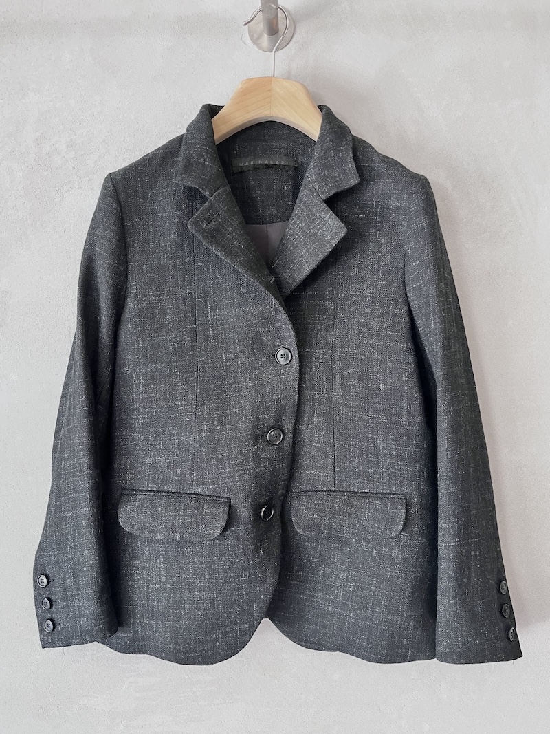 Giacca monopetto nera in lino e lana, con collo alto, revers asimmetrico, tasche a filetto con patta e fondo stondato, Marina Lari.