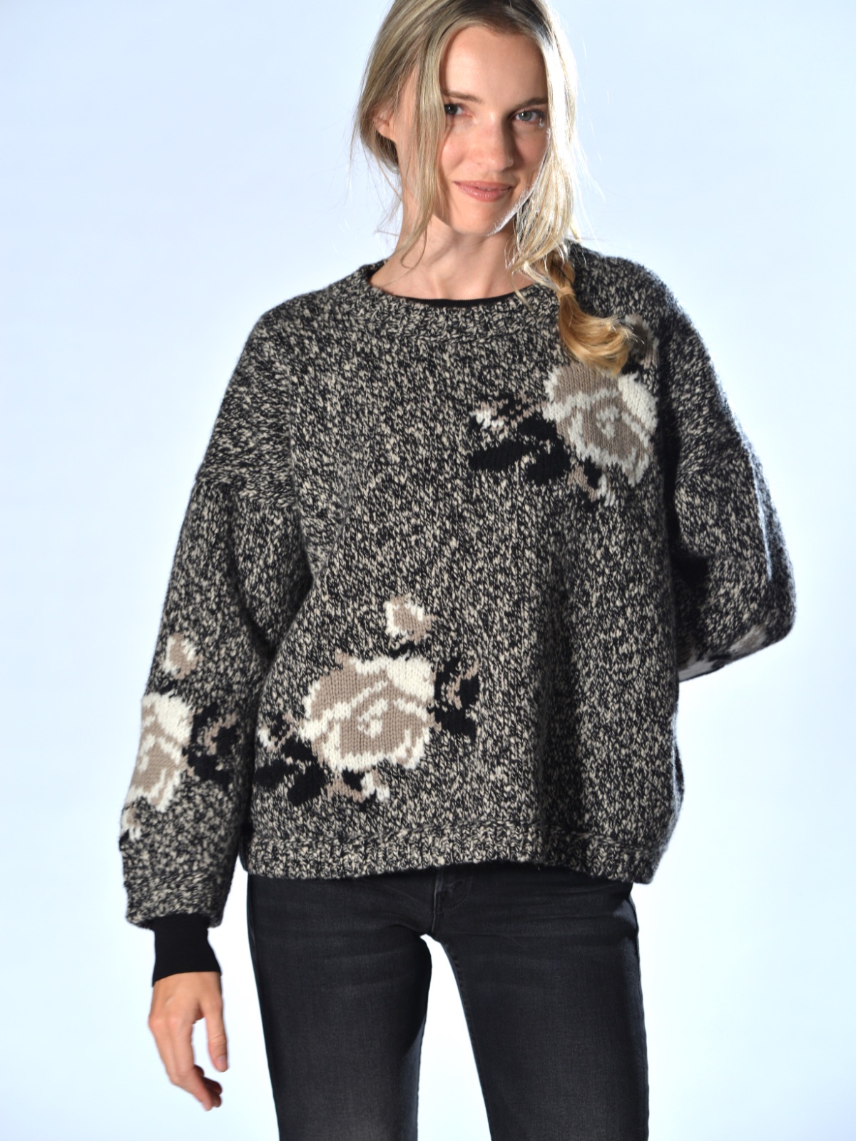 Maglia boxy nera in lana merino chiné, con intarsi floreali a contrasto, spalla calata e vestibilità over, Marina Lari.