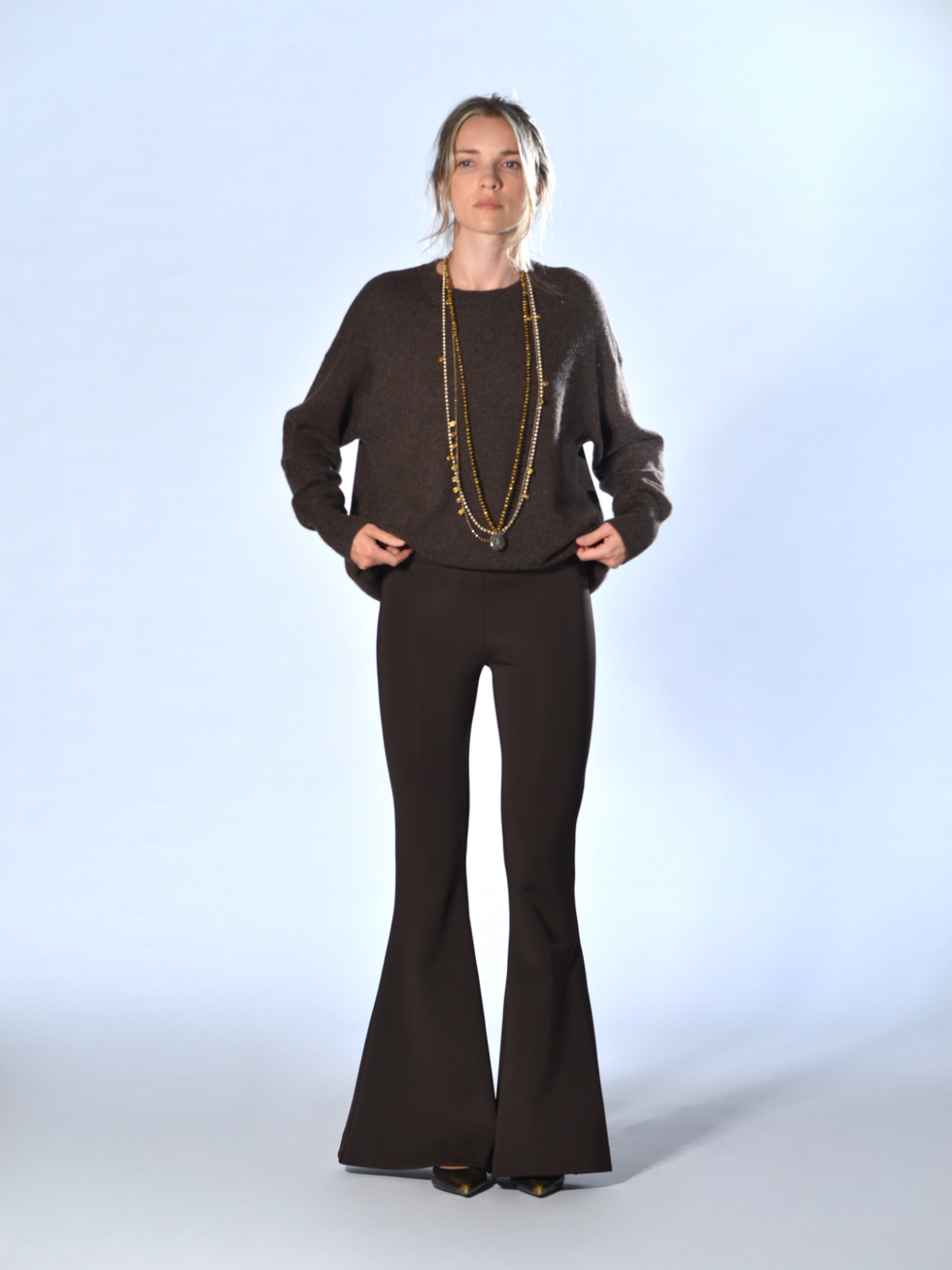 Pantaloni marroni a campana in tessuto tecnico elasticizzato, con vita alta, fascia con elastico interno e fondo ampiamente svasato, Marina Lari.