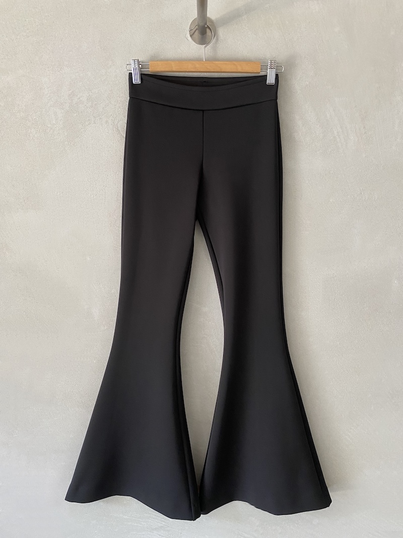 Pantaloni neri a campana in tessuto tecnico elasticizzato, con vita alta, fascia con elastico interno e fondo ampiamente svasato, Marina Lari.