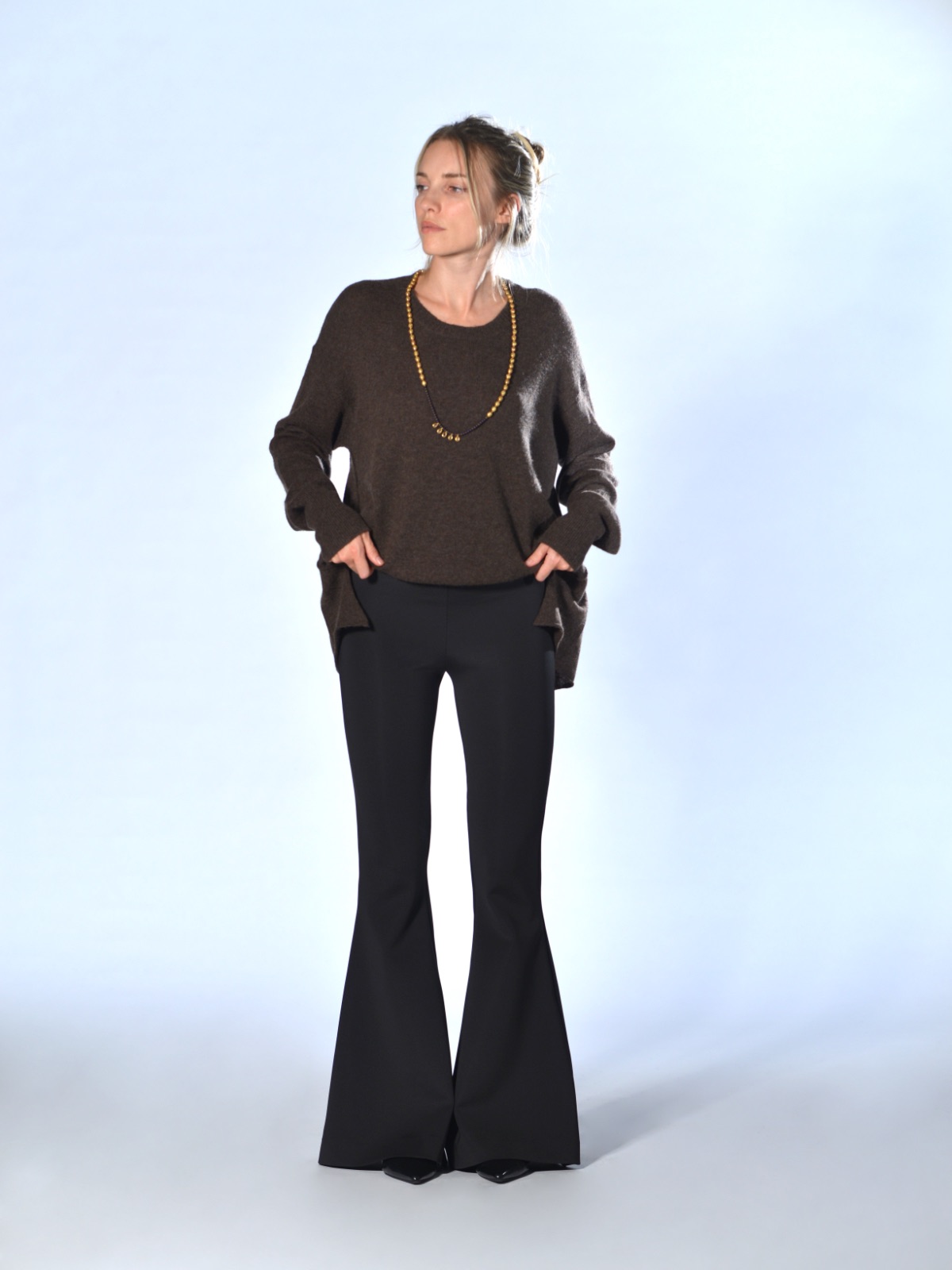 Pantaloni neri a campana in tessuto tecnico elasticizzato, con vita alta, fascia con elastico interno e fondo ampiamente svasato, Marina Lari.