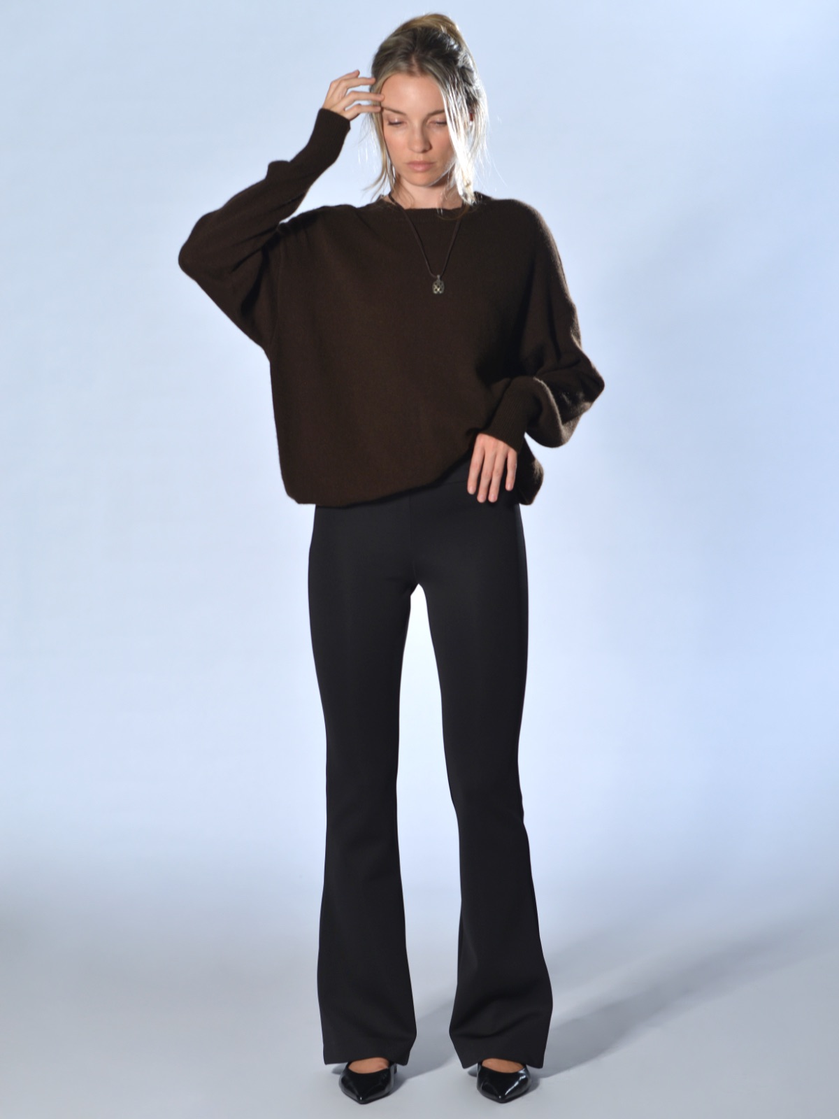Pantaloni neri a trombetta in tessuto tecnico elasticizzato, con vita alta, fascia con elastico interno e fondo svasato, Marina Lari.